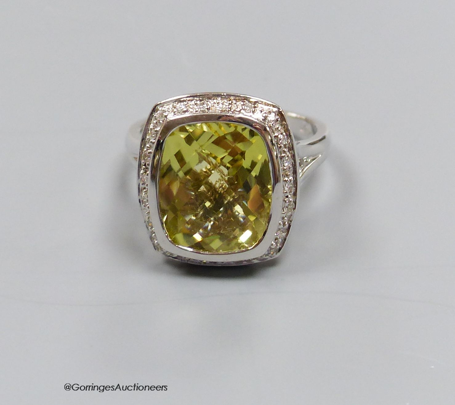 An 18ct white gold, diamond and lemon quartz cluster ring, size N, gross 7.3g.